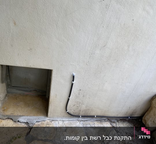 כבל שחור מחובר לקיר חיצוני עם תפסנים
